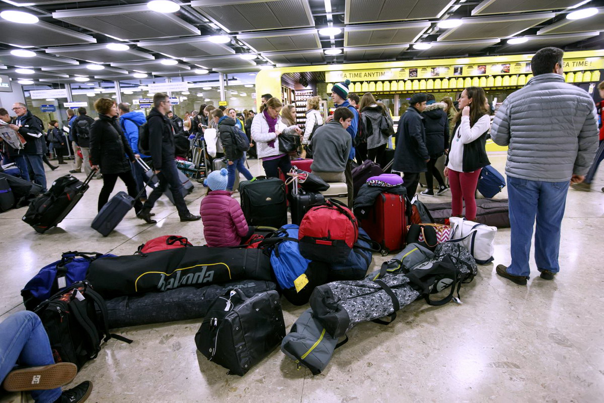 Flight passengers, with their luggages and ski bags, walk in the arrival hall of the Geneva Airport, in Geneva, Switzerland, Saturday, December 27, 2014. Thousands of skiers and travellers are expected during this week at the airport to celebrate New Year in ski resorts of Switzerland or in ski resorts of France. (KEYSTONE/Salvatore Di Nolfi)